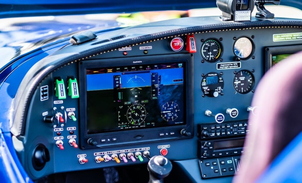A cockpit view showcasing an array of instruments, digital displays, and controls in a vibrant setting.