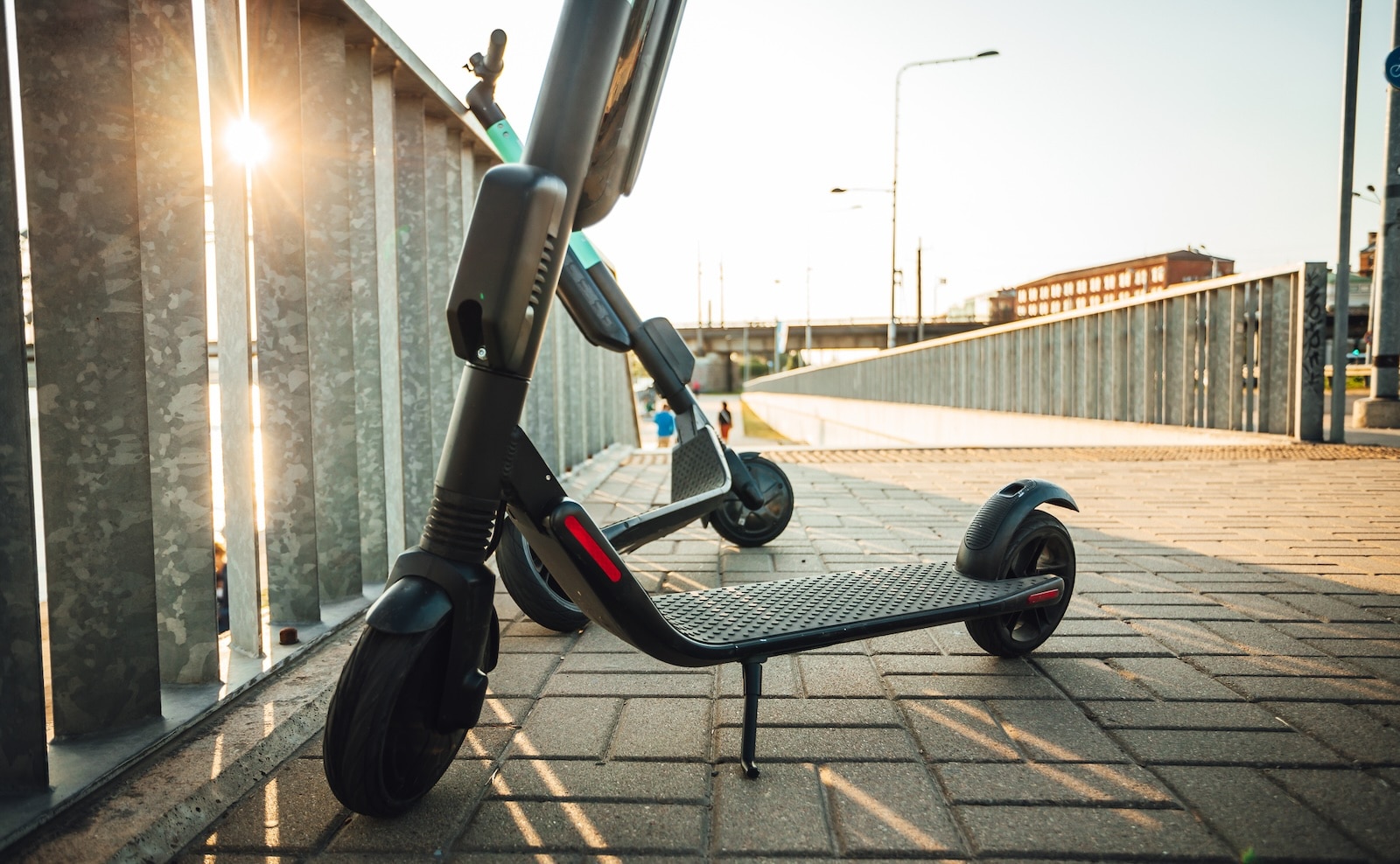 Micro-mobility efers to lightweight, often electric, transportation options for short-distance travel. Image showing electric scooters parked on a bridge.